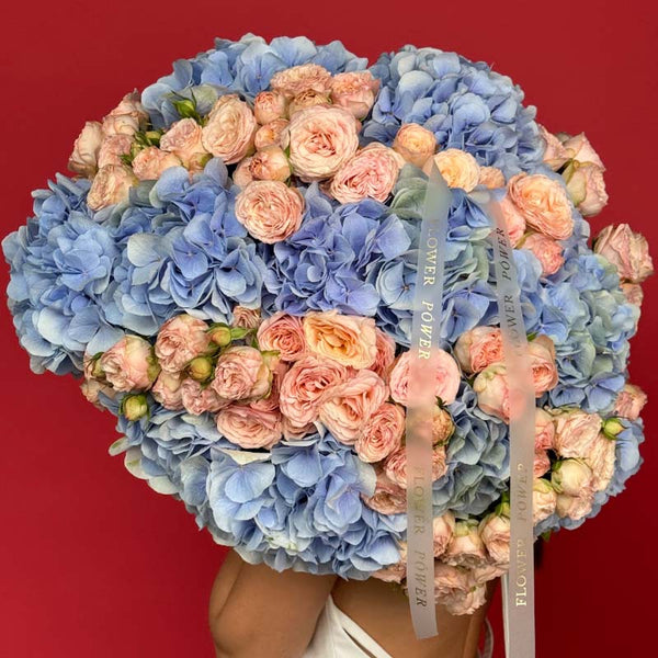 Bouquet of blue hydrangeas and peach spray roses Azure Peach