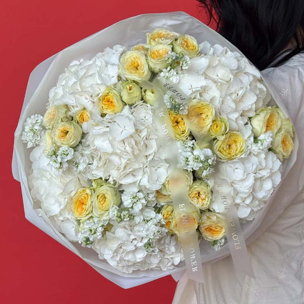 Bouquet of creamy hydrangeas and yellow garden roses Golden Whisper