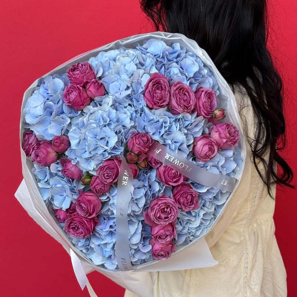 Bouquet of blue hydrangeas and mauve garden spray roses Velvet Ocean M